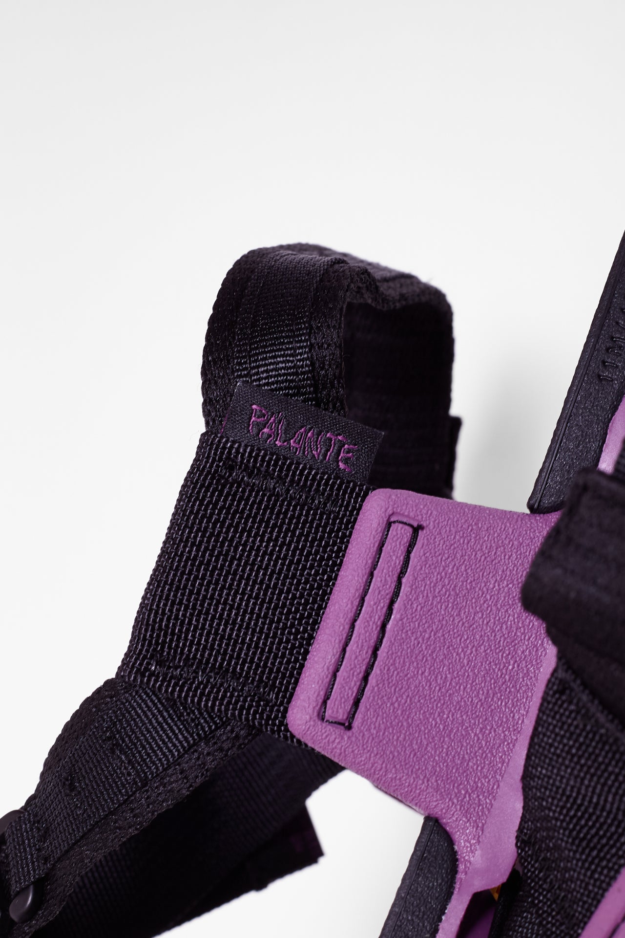 Pair of black and purple sandals on a white background